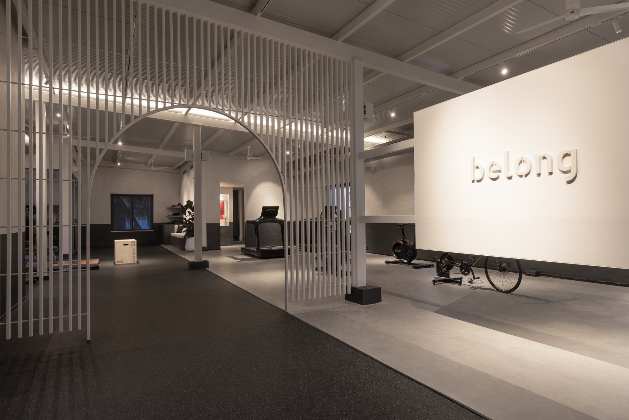 The Belong floor: a white slatted arch, the word belong on the far wall, rubber and concrete floor.